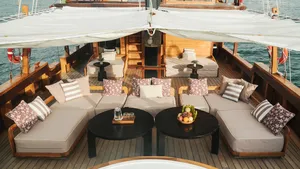 Angelica Liveaboard sundeck lounge with cushioned seating and dining tables on a 3D2N luxe Komodo cruise in Labuan Bajo