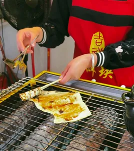 Grilled skewers on a street grill, served by a vendor in Lijiang during a food hunt with local stories
