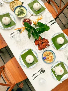 Malaysian comfort-food meal spread on plates and banana leaves at Kebun Lidstari, with rice, spiced meat and soup in Langkawi.