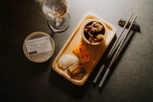Rare sake tasting spread in a tucked-away Singapore shop with small pour glasses, appetisers and chopsticks on a tray — SakeMama