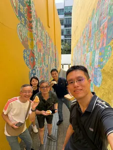 Team members holding ice creams and smiling in a colourful lane during a real-life Monopoly challenge in Katong-Joo Chiat, Singapore hidden gems