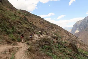 Small group hiking along a dusty ridge path on the high trail of Tiger Leaping Gorge on a 2D1N trek with The Bivou Lijiang, Lijiang