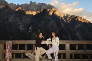 Hikers posing by a wooden viewing deck with rugged peaks above Tiger Leaping Gorge near Lijiang at sunset on a 2D1N high trail