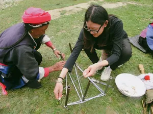 Khampa Caravan-led family homestay craft outdoors in Shangri-La, with two people working at a small table on the lawn