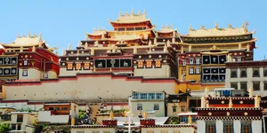 Traditional Tibetan monastery with ornate multi-storey pagoda roofs against blue sky in Shangri-La during daytime