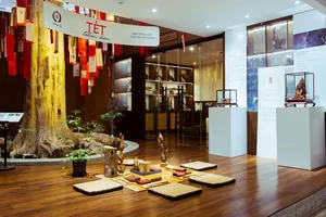 Museum-style exhibition in Hanoi showing artefacts and sliced agarwood samples under glass cases, with red festive banners