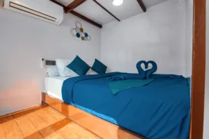 Blue bed cabin aboard a phinisi for a private 3D2N Komodo cruise, made up for relaxing on the way to Komodo Island