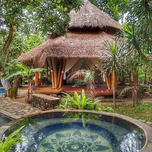 Thatched meditation pavilion and outdoor plunge pool at Omunity Bali retreat in lush garden courtyards, Bali