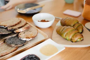 Sliced bread and small stuffed rolls on wooden boards during shio pan and flavoured butter hands-on workshops in Singapore