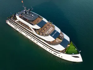 Doris Cruise 2D1N cruise ship gliding across Lan Ha Bay, aerial view over calm Vietnamese waters aboard the luxury vessel