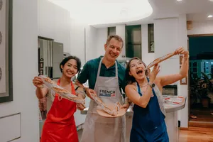 Singapore cosy loft French baguette workshop at French Cooking Lab: smiling guests holding flour-dusted baguettes, workshops in Singapore