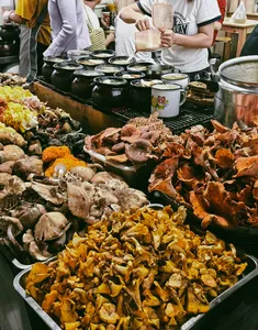 Lijiang street food stall with trays of grilled and spiced dishes and paper cups, as part of a local stories food hunt