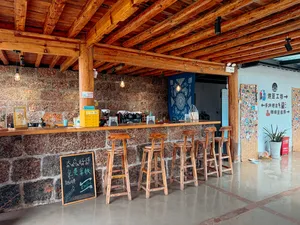 Wooden guest counter with bar stools and a chalkboard menu at Seeker Yunnan Coffee Estate, a family-run coffee workshop in Lijiang
