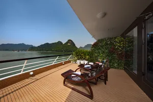 Sun deck on the Oasis Bay Party Cruiser with two wooden loungers, potted plants and lagoon views of surrounding islands on the Halong Bay
