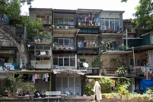 Weathered multi-storey apartment blocks with metal-framed balconies and laundry lines in a Hanoi collective housing neighbourhood