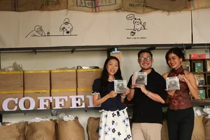Seeker Yunnan Coffee Estate in Lijiang: visitors pose with packaged coffee samples at a coffee counter with signage