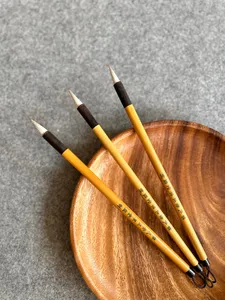 Chinese calligraphy brushes resting in a wooden dish for 'Write Your Own Blessing' in Singapore—workshops in Singapore
