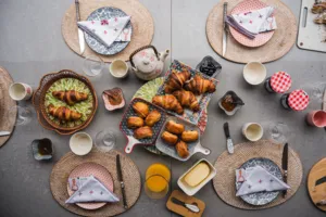 Overhead breakfast table set with croissants, cups and teapot at a French Cooking Lab session in Singapore, workshops in Singapore
