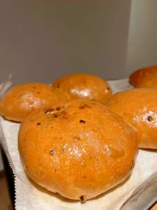托盘上摆着金黄微褐的餐包,表面微微起泡,在新加坡的亲手面包制作工作坊中暖暖上桌