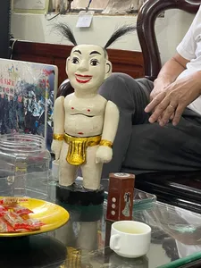 Bamboo Life 私享河内水上木偶体验中,展示桌上摆放着彩绘木质水上木偶和茶杯