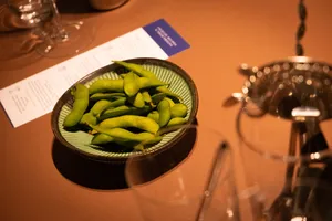 Close-up cabai hijau yang disajikan bersama menu koktail dan perlengkapan gelas di atas meja di bar intim di Singapura