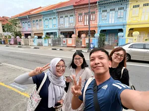 Friends posing beside colourful Katong-Joo Chiat shophouses in Singapore during a real-life Monopoly team game  Singapore hidden gems