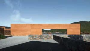 Teras eco-retreat Linden Centre di Shaxi, Dali, dengan halaman kerikil, dinding batu melengkung, dan pemandangan pegunungan menghadap kota