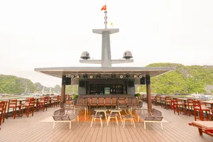 Sunshine Golden Cruises open-air dining deck with rows of tables and red chairs on a luxury Cat Ba cruise, facing the bay