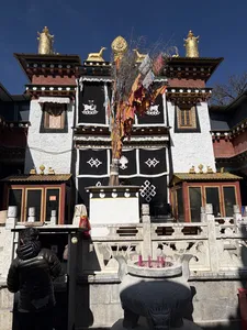 Decorated Tibetan courtyard doorway with prayer flags at Mission Liotard in Shangri-La, Yunnan, offering a cultural resting stop