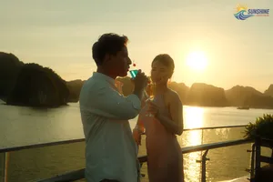 Sunshine Golden Cruises guests smiling and toasting on the deck at sunset over the bay during a luxe 2D1N Cat Ba cruise