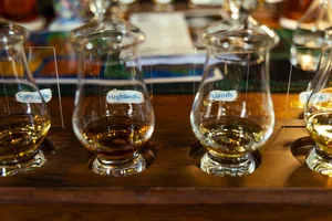 Row of whisky tasting glasses labelled Speyside, Highlands and Islands on a wooden table during Scotch & Sambal’s Singapore session
