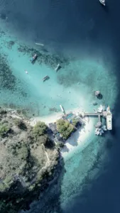 Aerial view of anchored boats over clear reef shallows during snorkelling on a cruise to Komodo Island