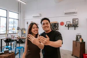 Couple smiling and showing handmade rings at Fat Anvil Studios silversmithing studio in Singapore for date ideas Singapore