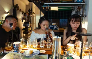 Glasses of small-batch whisky on a candlelit table as guests taste in a host-led hidden home bar in Katong, Singapore together