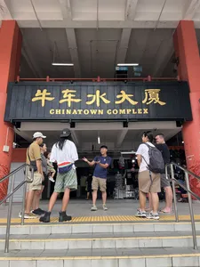 Travellers waiting by the entrance sign at Chinatown Complex in Singapore before joining the Cantonese fish tour and hawker walk