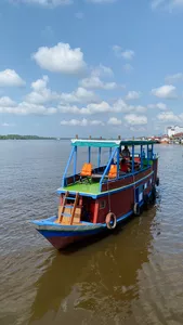 Tanjung Puting small boat cruise on a river, Sister Tour vessel with orange life jackets and passengers near Pangkalan Bun