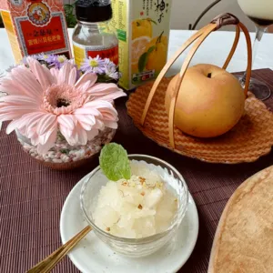 TCM-inspired mocktail tasting setup with tall glass in a wicker basket, herbal bottles and a bowl of pale jelly—workshops in Singapore