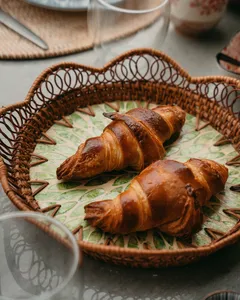Fresh croissants arranged in a wicker basket on a patterned tablecloth during a French Cooking Lab workshop in Singapore