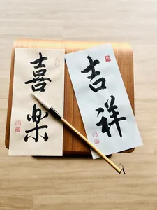 Chinese calligraphy sheets on a wooden writing board with a brush, ready to write a blessing—workshops in Singapore