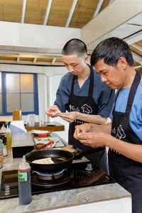 Host-led cooking class on Gili T, Lombok: participants pan-fry ingredients while learning to make peanut sauce