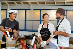 Cooking class on Gili T, Lombok: Gili Cooking Classes hosts explain Indonesian cooking to a small group in aprons
