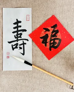 Calligraphy practice sheet with a bold black Chinese character and red seal, plus a brush on paper in Singapore—workshops in Singapore