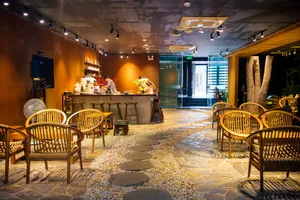 Courtyard café interior used for the Rare Agarwood Tour in Hanoi, with display shelves, a service counter and rows of rattan chairs