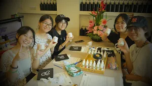 Smiling group at Perfume Play’s workshops in Singapore, making scented coco-soy candles with fragrance tools on a shared table