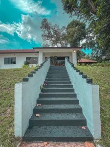 Stairway to a white bungalow at a Singapore 2D1N farmstay by the sea, set among greenery and hedges