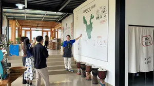 Guide points to a large Yunnan coffee map in the Seeker Yunnan Coffee Estate workshop in Lijiang, with sample cups