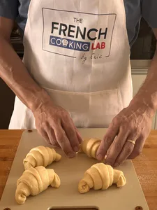 Di bengkel di Singapura, tangan pembuat roti French Cooking Lab menggulung doh croissant di atas papan kayu, sedia untuk dibakar