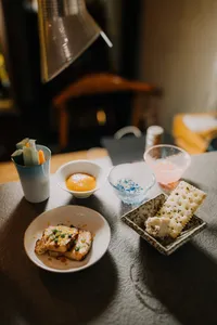 Close-up of a Singapore sake tasting table with small appetiser plates, dipping sauces and chilled cups of sake—SakeMama