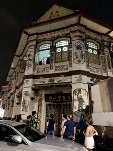 Ornate heritage shophouse facade with visitors outside on Indie Singapore Tours’ private night walk through Geylang, Singapore hidden gems
