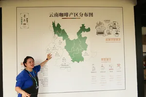 Seeker Yunnan Coffee Estate host in Lijiang pointing to a wall poster map of Yunnan’s coffee regions today